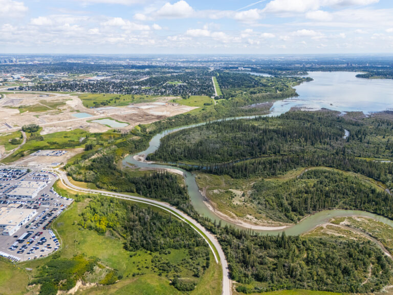 aerial view of the lush, green weaselhead flats and winding elbow river bordering Taza Park development