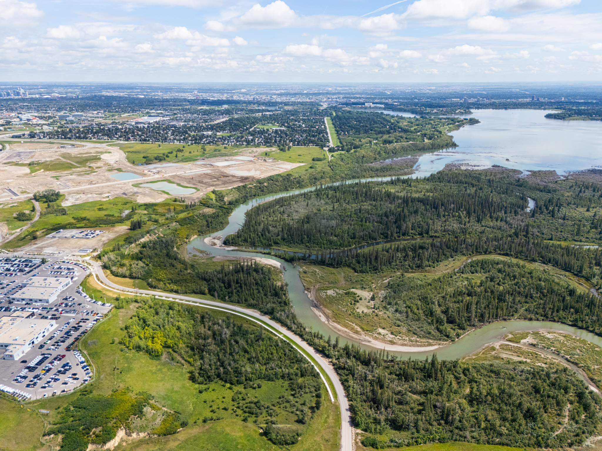 aerial view of the lush, green weaselhead flats and winding elbow river bordering Taza Park development