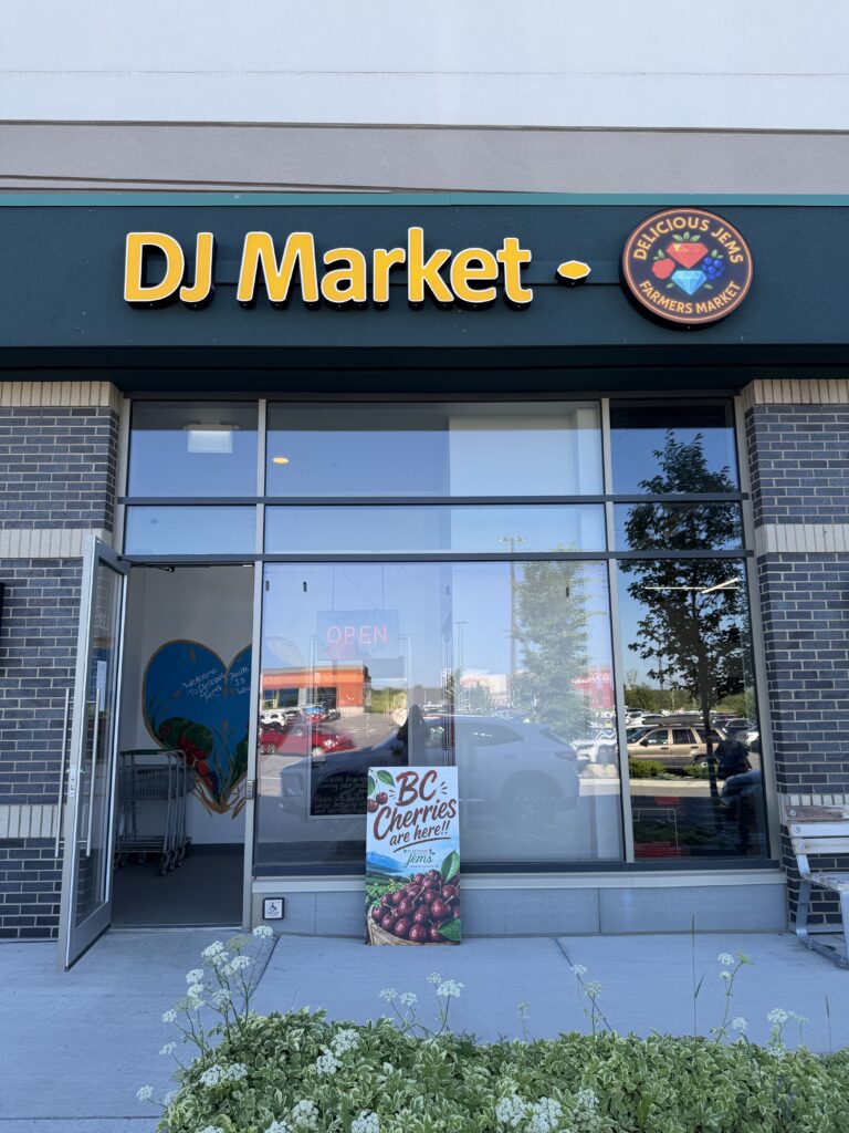 Storefront of DJ Market with a sign for BC Cherries
