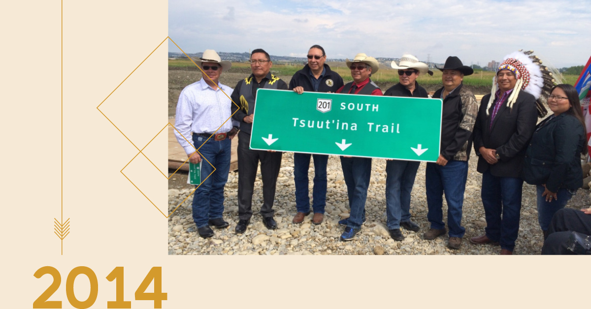 Members of Tsuut'ina Nation holding up a sign for the completed "Tsuut'ina Trail" portion of the Calgary ring road.